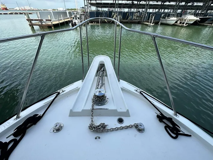 The Godfather Yacht Photos Pics 1986 Hatteras 52 Convertible yacht bow with anchor chain, docked in marina.