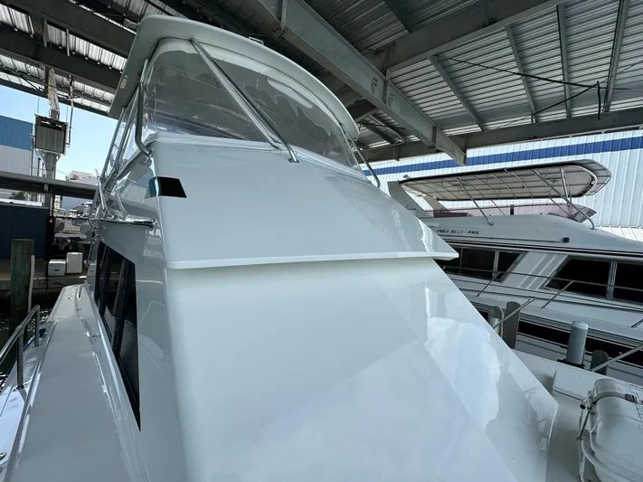 The Godfather Yacht Photos Pics 1986 Hatteras 52 Convertible yacht in marina, under a metal roof.