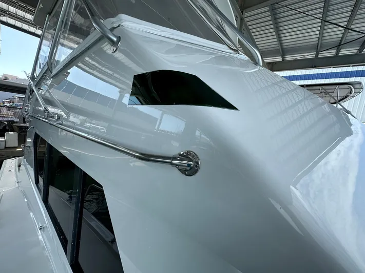 The Godfather Yacht Photos Pics 1986 Hatteras 52 Convertible yacht, sleek white exterior, docked under a metal roof.