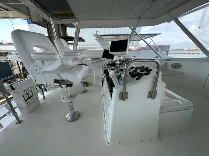 The Godfather Yacht Photos Pics Interior helm of 1986 Hatteras 52 Convertible yacht with white captain chairs and navigation equipment.