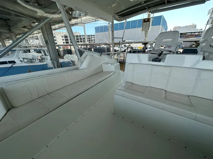 The Godfather Yacht Photos Pics Interior of 1986 Hatteras 52 Convertible yacht with white seating and helm chairs.