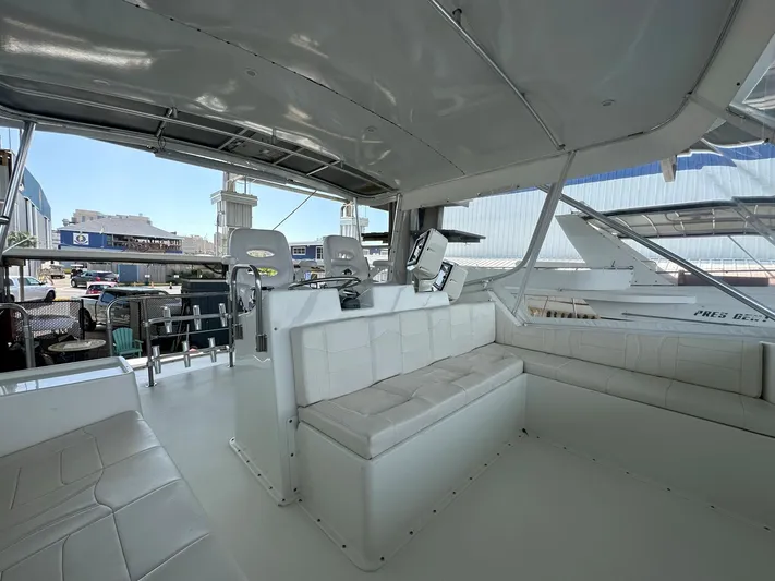 The Godfather Yacht Photos Pics Interior of 1986 Hatteras 52 Convertible yacht with white seating and helm station.