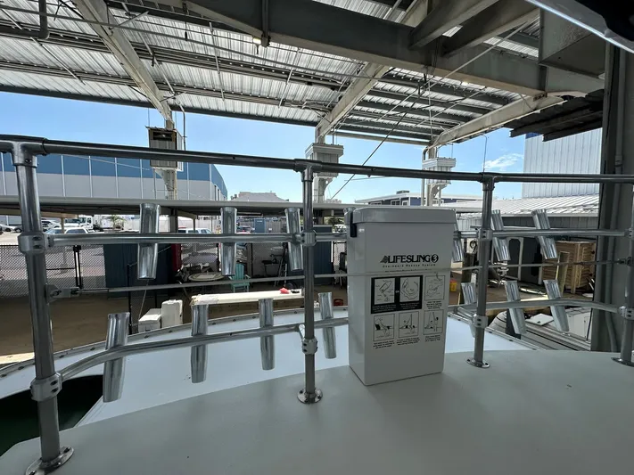 The Godfather Yacht Photos Pics 1986 Hatteras 52 Convertible boat deck with lifesaving equipment under a metal canopy.
