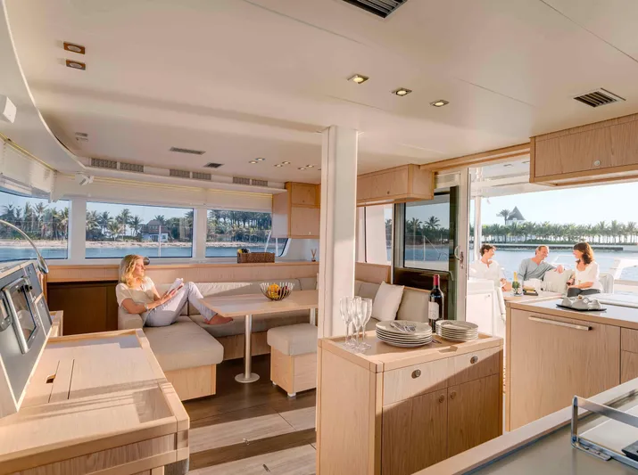 Parlay 2 Yacht Photos Pics Luxurious interior of 2020 Lagoon 52 F yacht with people relaxing and dining.