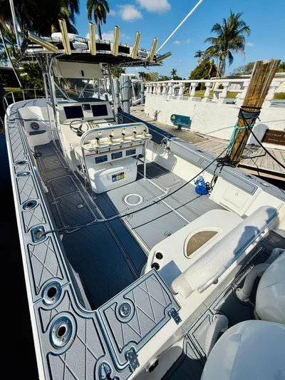  Yacht Photos Pics 2003 Fountain 38 TE boat with spacious deck and fishing equipment, docked under clear skies.