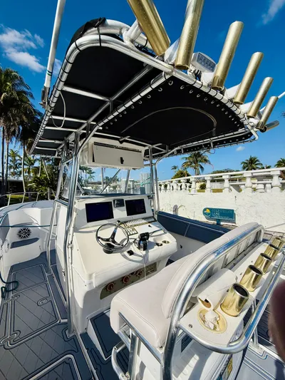 Yacht Photos Pics 2003 Fountain 38 TE boat with helm, rod holders, and palm trees in the background.