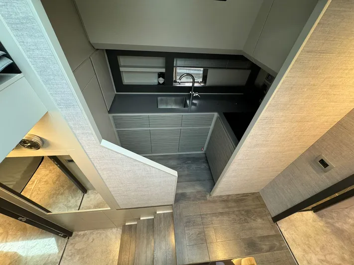  Yacht Photos Pics Modern kitchen interior of 2023 Pershing 6X yacht, featuring sleek cabinetry and minimalist design.