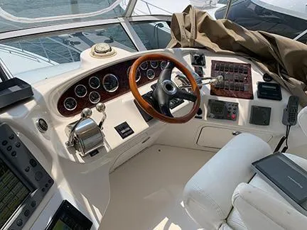  Yacht Photos Pics Helm of 2003 Sea Ray 400 Sedan Bridge with wood accents and navigation controls.