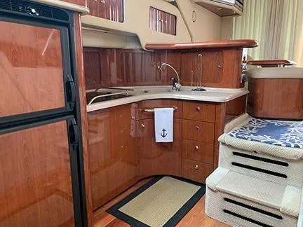  Yacht Photos Pics 2003 Sea Ray 400 Sedan Bridge yacht interior with wooden cabinetry and compact kitchen area.