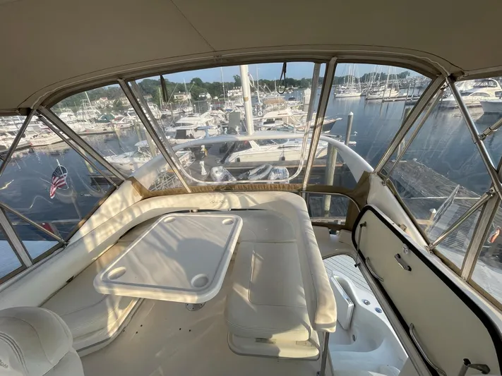  Yacht Photos Pics 2003 Sea Ray 400 Sedan Bridge interior with marina view, featuring seating and table.