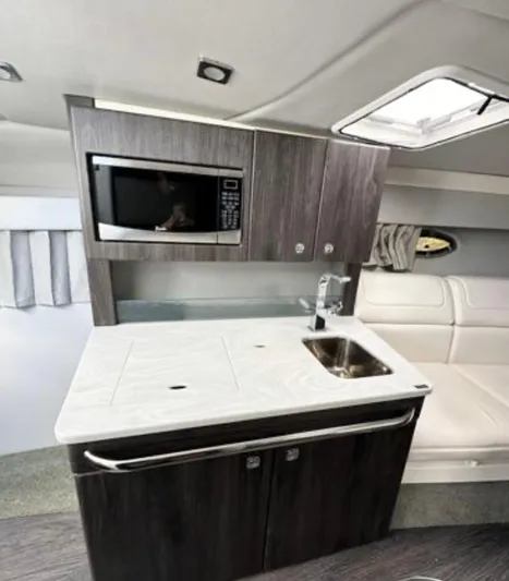  Yacht Photos Pics 2020 Formula 350 Sun Sport interior with kitchenette, featuring microwave, sink, and modern cabinetry.
