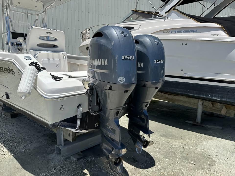 2018 Release 232 RX Center Console with twin Yamaha 150 engines, docked beside another boat.