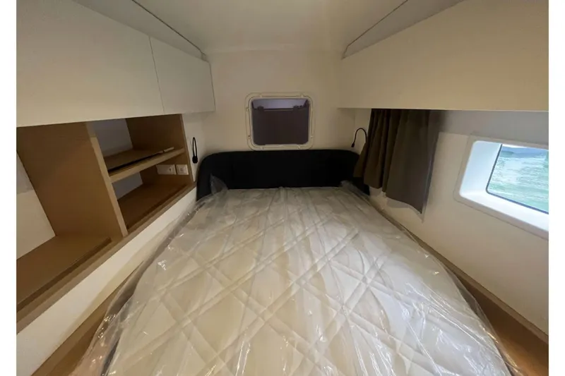 Fonn Taistil Domhain Yacht Photos Pics 2025 Fountaine Pajot 41 yacht cabin with bed, shelves, and windows.