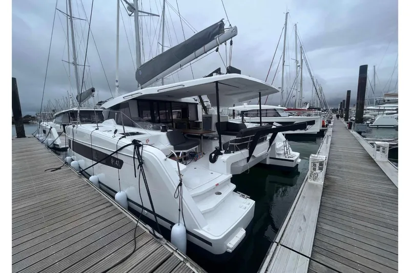 Fonn Taistil Domhain Yacht Photos Pics 2025 Fountaine Pajot 41 catamaran docked at marina, overcast sky, modern design.