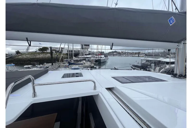 Fonn Taistil Domhain Yacht Photos Pics 2025 Fountaine Pajot 41 catamaran docked in a marina, showcasing sleek design and spacious deck.