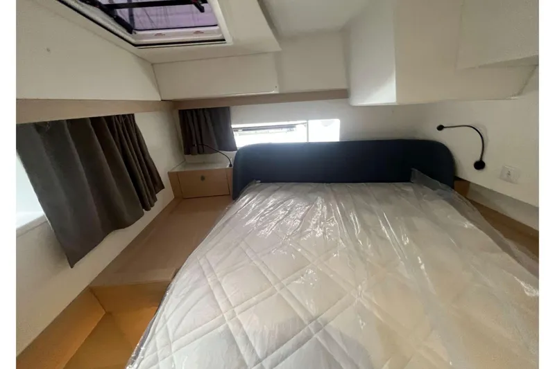 Fonn Taistil Domhain Yacht Photos Pics Cozy cabin interior of 2025 Fountaine Pajot 41 yacht with bed and window.