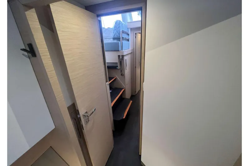 Fonn Taistil Domhain Yacht Photos Pics Interior hallway of 2025 Fountaine Pajot 41 catamaran with wooden doors and steps.