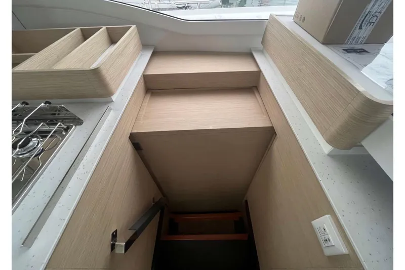 Fonn Taistil Domhain Yacht Photos Pics Modern kitchen interior of 2025 Fountaine Pajot 41 yacht, featuring sleek wood cabinetry.