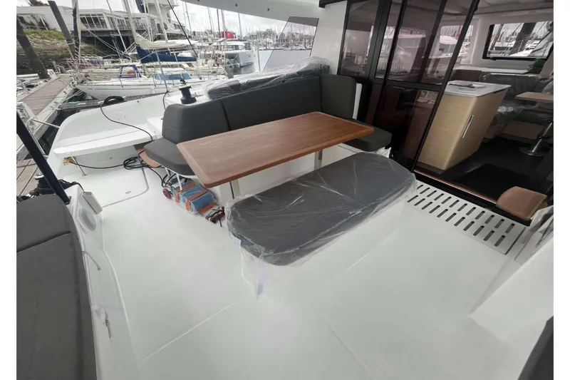 Fonn Taistil Domhain Yacht Photos Pics 2025 Fountaine Pajot 41 yacht interior with seating area and wooden table.