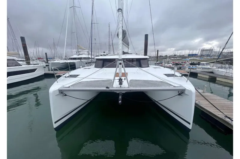 Fonn Taistil Domhain Yacht Photos Pics 2025 Fountaine Pajot 41 catamaran docked in a marina under cloudy skies.