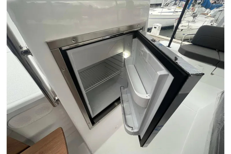 Fonn Taistil Domhain Yacht Photos Pics Open mini fridge on 2025 Fountaine Pajot 41 yacht, docked with other boats visible.