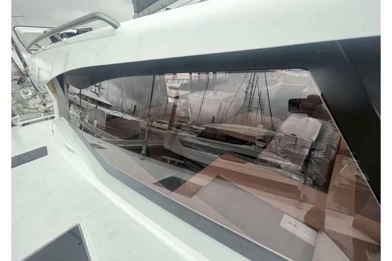Fonn Taistil Domhain Yacht Photos Pics 2025 Fountaine Pajot 41 yacht window reflecting marina view.