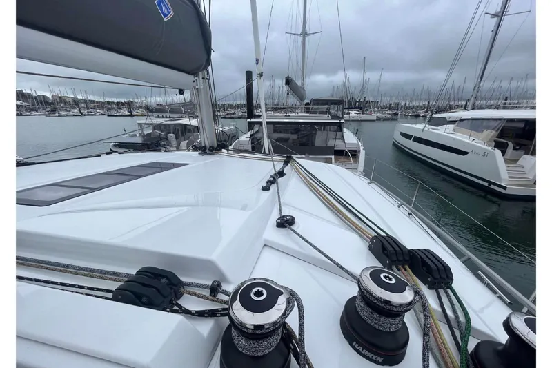 Fonn Taistil Domhain Yacht Photos Pics 2025 Fountaine Pajot 41 catamaran docked in a marina, surrounded by sailboats.