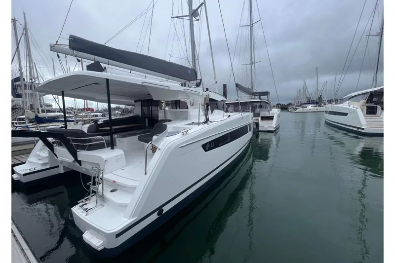 Fonn Taistil Domhain Yacht Photos Pics 2025 Fountaine Pajot 41 catamaran docked in a marina on a cloudy day.