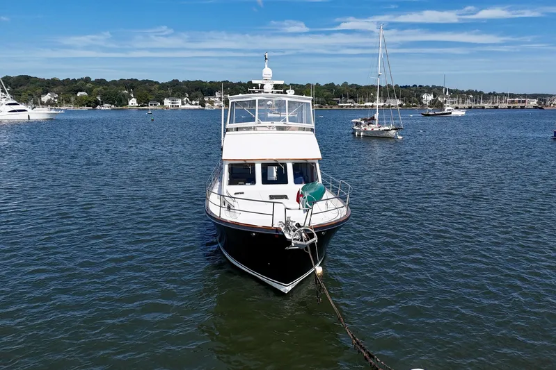 Destiny Yacht Photos Pics Sabreline 47 yacht from 1997 anchored in a scenic harbor with sailboats.