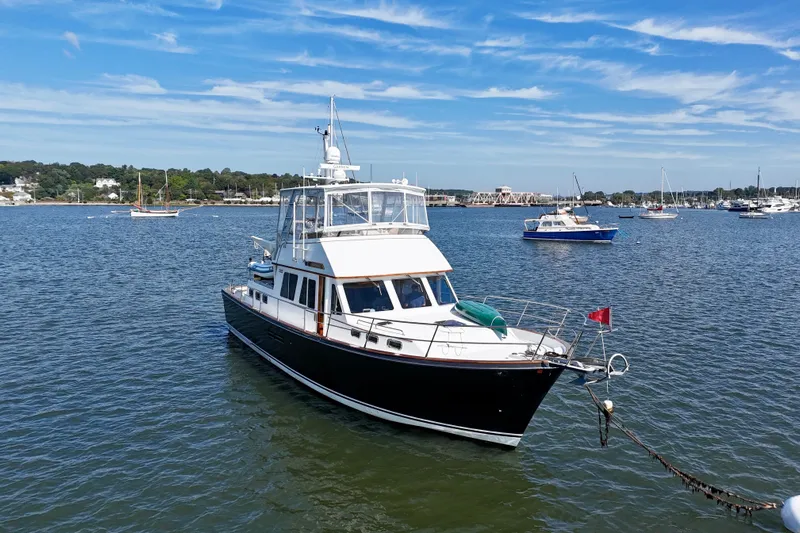 Destiny Yacht Photos Pics 1997 Sabre Sabreline 47 yacht anchored in a scenic harbor with blue skies.