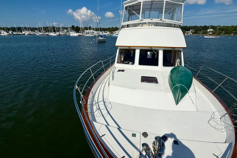 Destiny Yacht Photos Pics 1997 Sabre Sabreline 47 yacht on calm water, with marina and blue sky background.