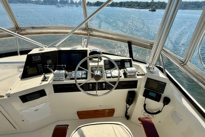 Destiny Yacht Photos Pics 1997 Sabre Sabreline 47 yacht helm with navigation instruments and steering wheel, overlooking calm waters.
