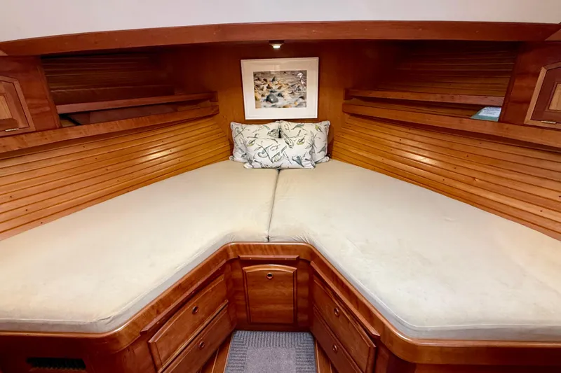Destiny Yacht Photos Pics 1997 Sabre Sabreline 47 yacht cabin with wooden interior and cozy bedding.