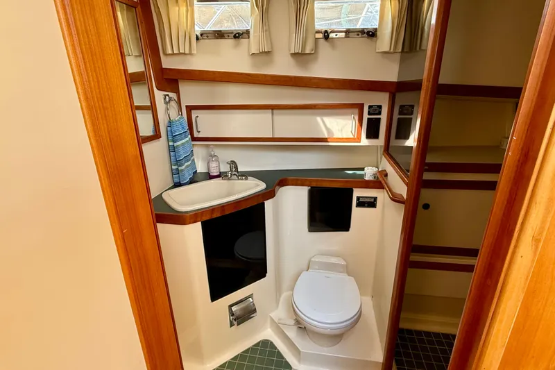 Destiny Yacht Photos Pics Bathroom interior of 1997 Sabreline 47 yacht with sink, toilet, and wooden accents.