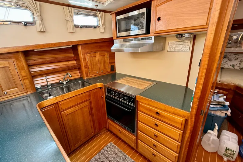 Destiny Yacht Photos Pics 1997 Sabre Sabreline 47 yacht kitchen with wood cabinetry, stove, and microwave.