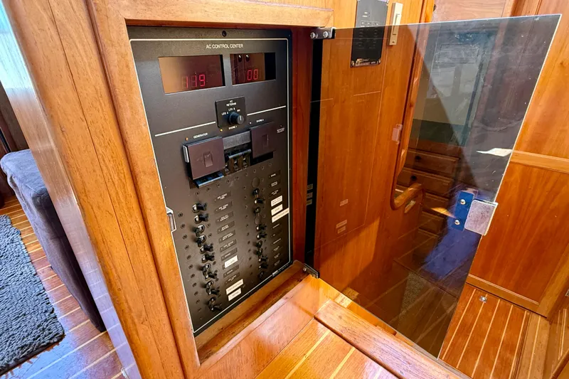 Destiny Yacht Photos Pics Electrical control panel inside 1997 Sabre Sabreline 47 yacht, featuring wooden cabinetry.