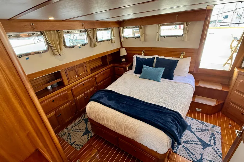Destiny Yacht Photos Pics Luxurious 1997 Sabreline 47 yacht bedroom with wood paneling and cozy bedding.