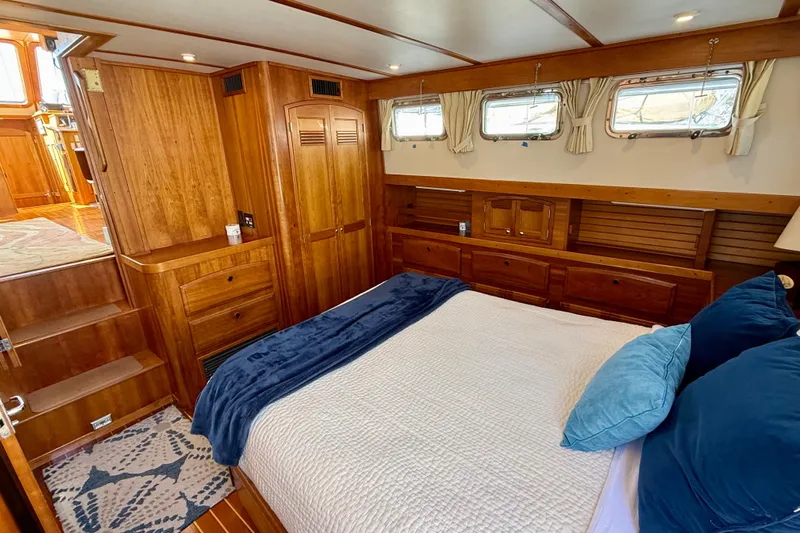 Destiny Yacht Photos Pics Luxurious 1997 Sabreline 47 yacht cabin with wooden interior and cozy bedding.