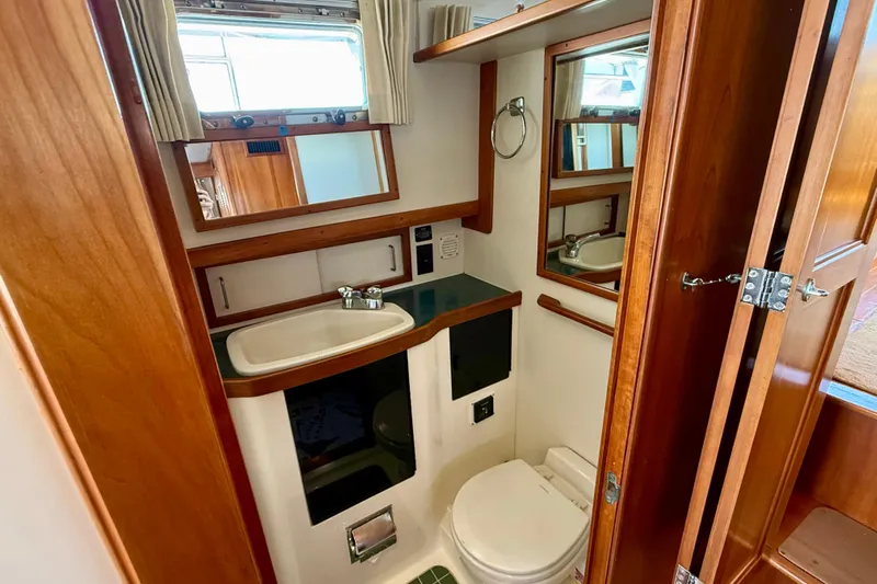 Destiny Yacht Photos Pics 1997 Sabre Sabreline 47 yacht bathroom with wooden cabinetry and compact design.