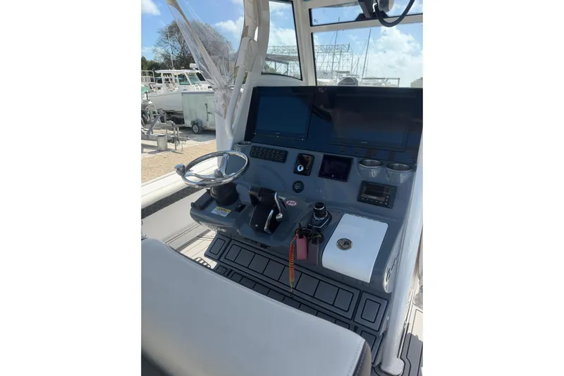  Yacht Photos Pics 2024 Tidewater 3100 Carolina Bay boat console with steering wheel and controls.