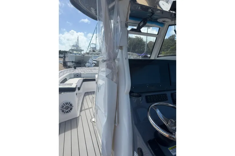  Yacht Photos Pics 2024 Tidewater 3100 Carolina Bay boat interior with steering wheel and seating area.