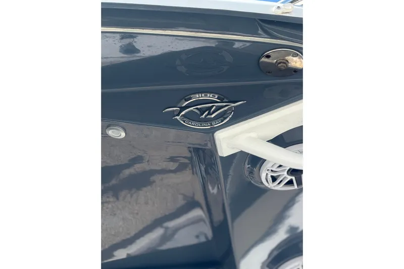  Yacht Photos Pics 2024 Tidewater 3100 Carolina Bay boat emblem on sleek blue hull.
