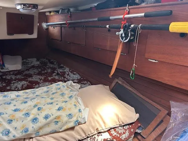 Exeter II Yacht Photos Pics Cozy cabin interior of a 1988 Sabre 38 sailboat with fishing rods and bedding.