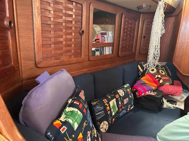 Exeter II Yacht Photos Pics 1988 Sabre 38 sailboat interior with colorful cushions and wooden cabinets.