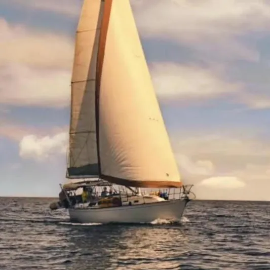 Exeter II Yacht Photos Pics 1988 Sabre 38 sailboat cruising on open water under a colorful sky.