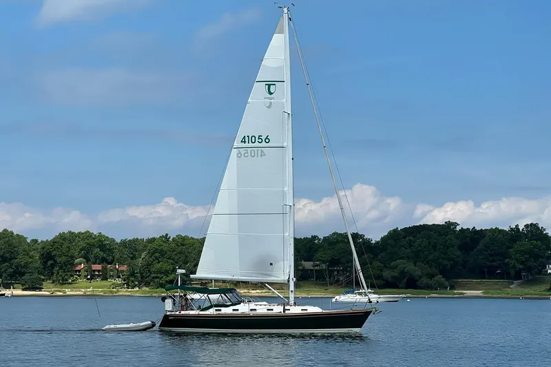 4869tw Yacht Photos Pics Sailboat Tartan 4100 from 2001 on a calm lake with lush green shoreline.