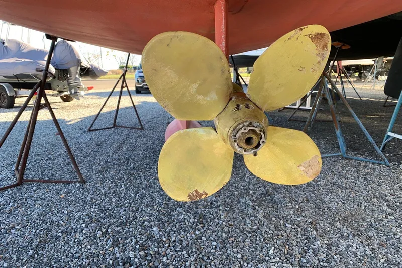 4869tw Yacht Photos Pics Yellow propeller of 2001 Tartan 4100 sailboat on gravel, supported by stands.