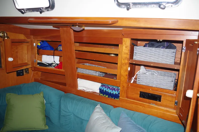 4869tw Yacht Photos Pics Interior of 2001 Tartan 4100 sailboat with wooden cabinets and cozy seating area.