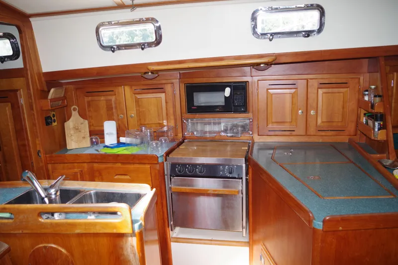 4869tw Yacht Photos Pics 2001 Tartan 4100 yacht kitchen with wooden cabinets and modern appliances.