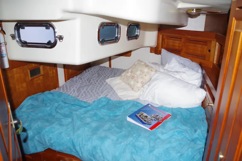 4869tw Yacht Photos Pics Cozy cabin interior of 2001 Tartan 4100 sailboat with bed and portholes.